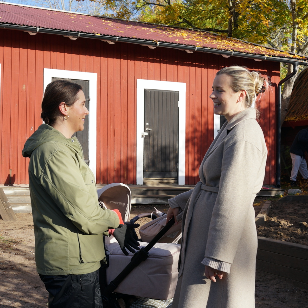 Två vuxna står och samtalar på Elefantens förskolegård under en städdag.